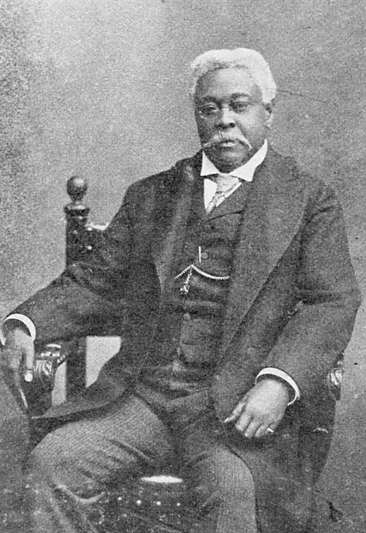 A studio photograph of David Augustus Straker sitting in a chair.