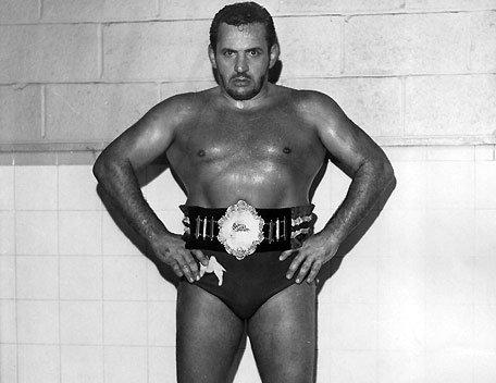 Edward Farhat, black and white photo of him wearing wrestling shorts a wrestling belt
