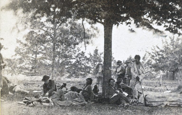 Photograph taken on the Brompton estate near Fredericksburg, Virginia after the battles at Nye River and Spottsylvania, May 1864. Tom Ke Che Ti Go is standing in the light colored clothes